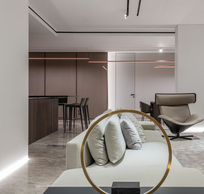Comfortable soft couch with cushions and dining zone in kitchen in modern studio interior